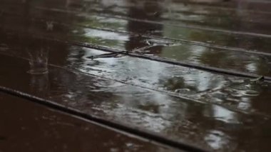 Kahverengi ahşap zeminde yağmur yağıyor. Yavaş çekim görüntüleri