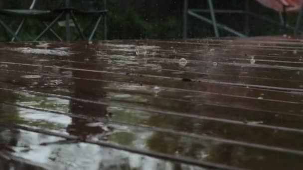 Vista de perto da chuva no chão de madeira marrom. Filmagem em câmara lenta — Vídeo de Stock