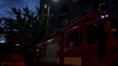 İtfaiye araçları ve gece sokakta yanıp sönen ışıklar olan yangın sahnesi. . 