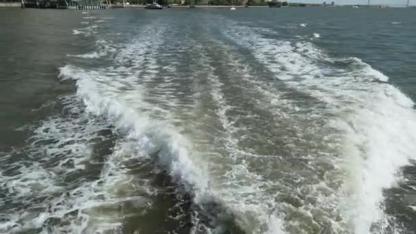 Волны со спины лодки над поверхностью воды — стоковое видео