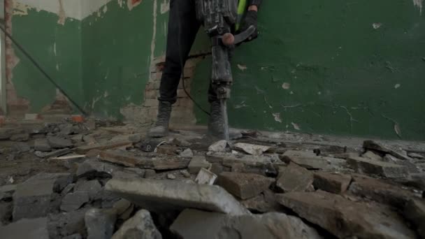 Stavební dělník s pneumatickým kladivem vrtačka sbíječka zařízení lámání betonové silnice na betonové podlaze — Stock video