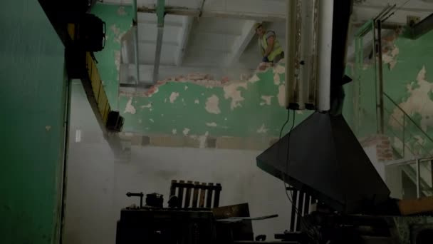 Sloop en herschikking. werknemer met hamer vernietigende muur — Stockvideo