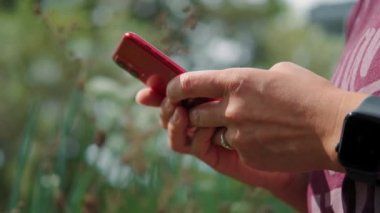 Kırmızı iPhone akıllı telefonu kullanarak kapatır, parmak basar, sosyal medyayı okur, metin yazar veya internetten alışveriş yapardı. 20.08.21 Chicago, ABD.