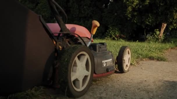 Vue rapprochée de l'homme couper l'herbe avec tondeuse à gazon dans la cour de la maison près de swing dans l'aire de jeux. Images au ralenti — Video