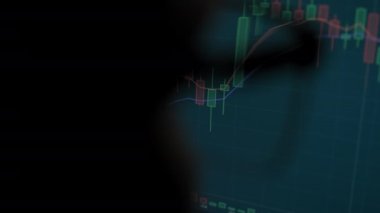 Gözlüklü Adam Borsacısı, grafikleri analiz etmenin yansımasıyla bilgisayar üzerinde çalışıyor. Kapat.. 