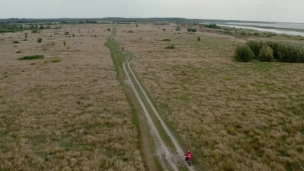 Imagens acima de drone de motoristas de motocicleta que viajam em uma estrada rural. — Vídeo de Stock