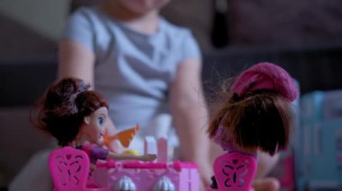 Küçük 6 yaşındaki kız odasında oyuncak bebeklerle oynuyor.