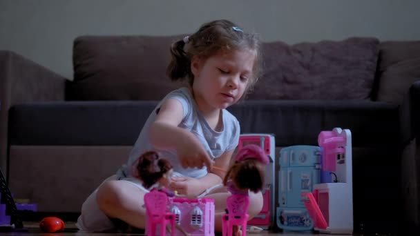 Kleines sechsjähriges Mädchen spielt in ihrem Zimmer mit einer Puppe. Zeitlupe — Stockvideo