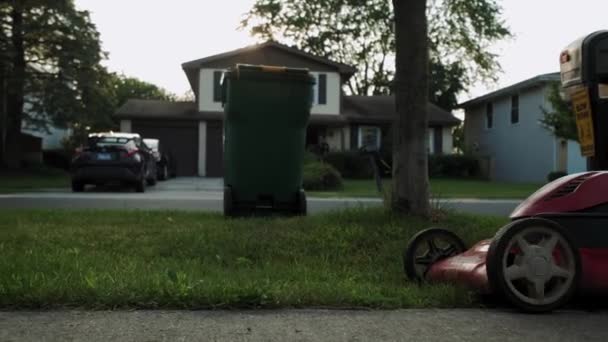 Ferme là. Homme coupé herbe avec tondeuse à gazon dans la cour de la maison près de swing dans l'aire de jeux. Images au ralenti — Video