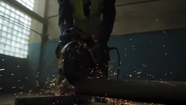 円形ののこぎりで鋼を切断建設労働者のビューを閉じる,建設労働者の足,円形ののこぎりから火花を飛んで.スローモーション — ストック動画
