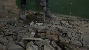 Pnömatik çekiç matkaplı inşaat işçisi beton zemindeki beton yolu kırıyor. Kapat.