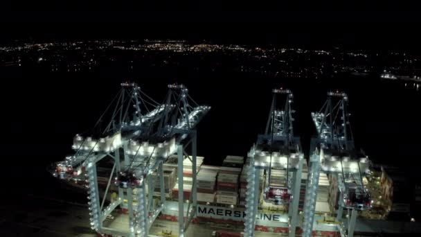 Geniş hava manzaralı. Kargo gemisinin kargo konteynırları limandaki bir rıhtımda duruyor. Gece vakti konteynırların yüklenip boşaltıldığı yerde... — Stok video