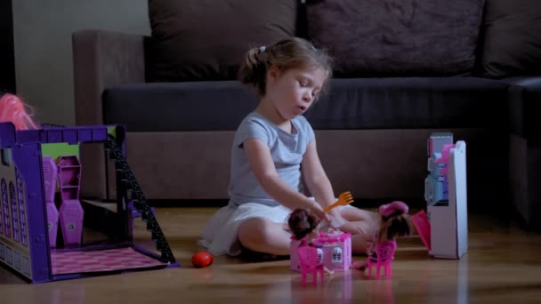 Odasında oyuncak bebeklerle oynayan altı yaşındaki küçük bir kız. Yavaş çekim Geniş çekim — Stok video