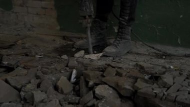 Pnömatik çekiç matkaplı inşaat işçisi beton zemindeki beton yolu kırıyor. Görüntüleri kapat