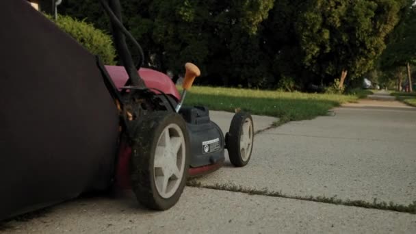 Close up imagens de Man cortar grama com cortador de grama no quintal da casa perto de balanço no parque infantil. Filmagem em câmara lenta — Vídeo de Stock