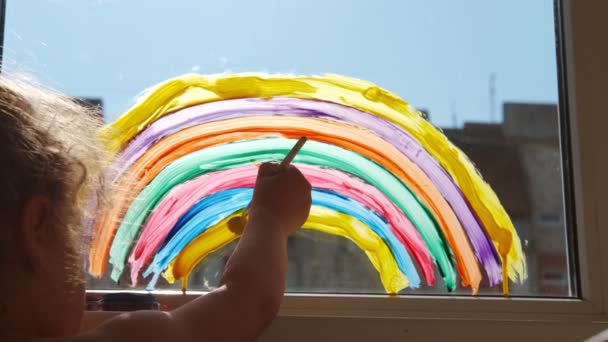 在家里的窗户上画彩虹。在阳光明媚的日子，呆在家里开展预防考拉病毒的社交媒体活动 — 图库视频影像