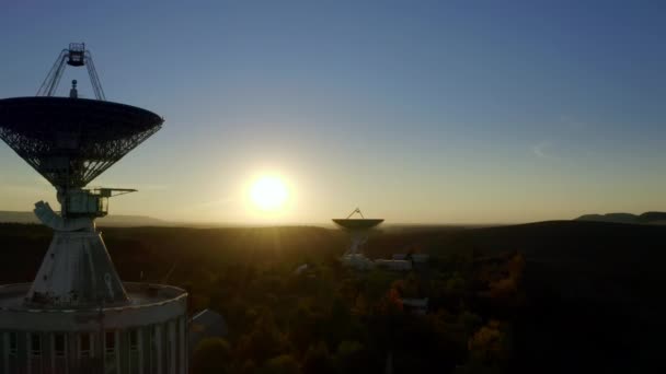 Letecký bezpilotní pohled na telekomunikační anténu nebo satelitní radioteleskop při západu slunce — Stock video