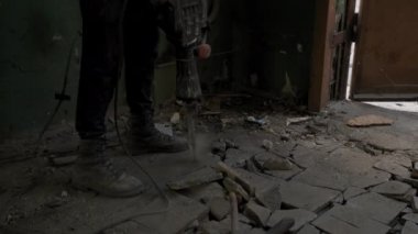 Görüntüleri kapat. Pnömatik çekiç matkaplı inşaat işçisi beton zemindeki beton yolu kıran matkap ekipmanı.. 