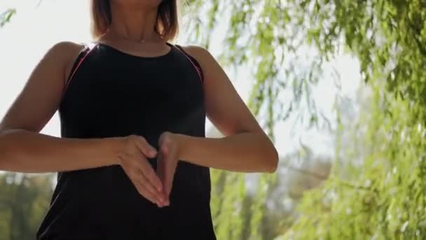 Flickan utför uppvärmningsövningar innan yoga i naturen n park. Närbild — Stockvideo
