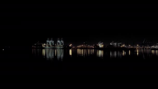 Brett flygfoto av lastfartyg med lastcontainrar står på en kaj i hamnen vid lastning och lossning av containrar på natten — Stockvideo