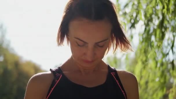 A menina realiza exercícios de aquecimento antes do ioga no parque de natureza n. Imagens de perto — Vídeo de Stock