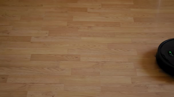 Výstřel. Smart vysavač robot běží na dřevěné podlaze v obývacím pokoji — Stock video