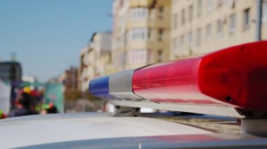 Polis arabası lambası yanıp sönen sinyal şehrin caddesinde duruyor. Kapat.