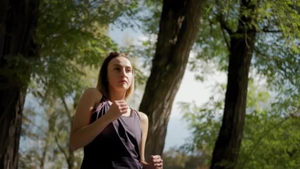 Kvinna som sitter på yogamattan och tränar yoga stretching utomhus på solig dag. Närbild — Stockvideo