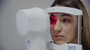 Göz doktorunun kamera görüntülerini kapatın hastaların gözlerini inceleyin ve sonra kameraya bakın..