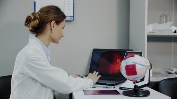 Um oftalmologista senta-se em uma mesa com vários dispositivos de diagnóstico — Vídeo de Stock