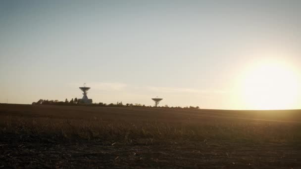 Wide Aerial drone shot of two telecommunications antenna or Radio telescope satellite dish on sunset — Stock Video