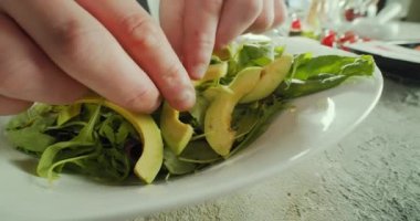 Şef lezzetli sebze ve avokado salatası pişiriyor.