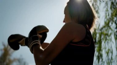 Boks eldivenli kadın güneşe karşı duruyor. Lviv 20 sep 2021 Ağır çekim