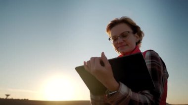 Tarlada tabletle çalışan çiftçi kadın hasat öncesi mahsul kalitesini analiz ediyor. Kapat.