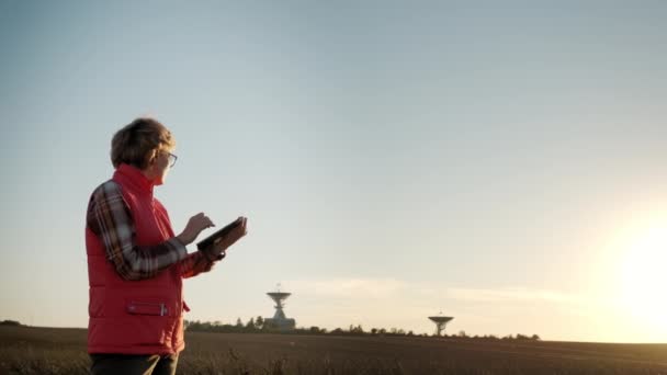 Mujer operador equipo tableta PC controla las antenas de radiotelescopio solar. Imágenes amplias. — Vídeo de stock