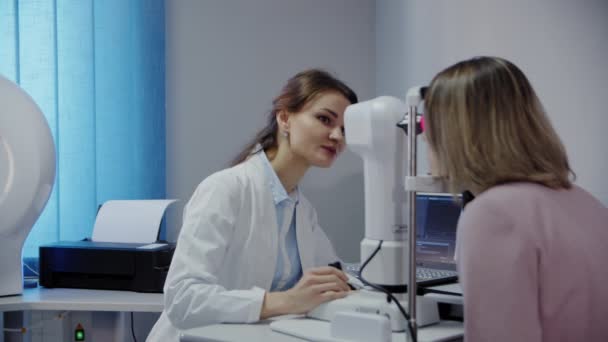 The ophthalmologist examines the patients eye and then looks into the camera. Wide view footage — Stock Video