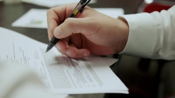 Resmi olarak işadamı, sözleşmenin şartlarını dikkatlice okuyup kâğıda imza atar.. — Stok video
