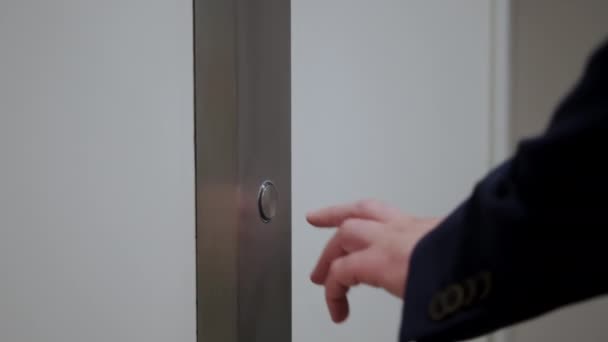 La mano de los hombres presiona el botón del ascensor para subir. De cerca. — Vídeos de Stock