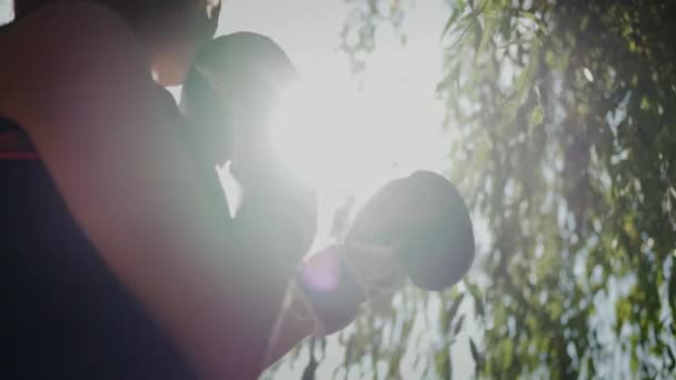 ผู้หญิงในถุงมือมวย ยืนต่อต้านดวงอาทิตย์ ลีฟ 20 sep 2021 — วีดีโอสต็อก