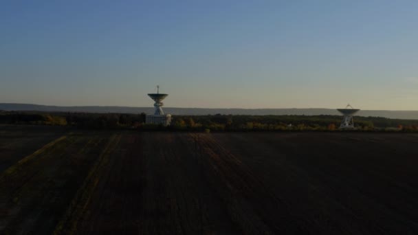 Szeroki widok zdjęcia drona z dwóch anteny telekomunikacyjnej lub anteny satelitarnej radioteleskopu na zachodzie słońca — Wideo stockowe
