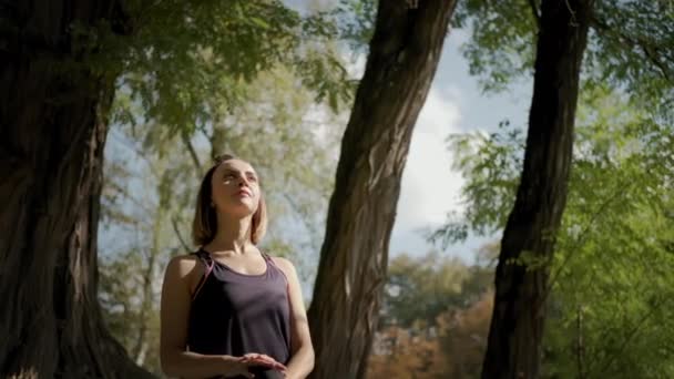 Nő gyakorolja jóga nyújtás gyakorlat a szabadban a napsütéses napon. Közelkép felvétel — Stock videók