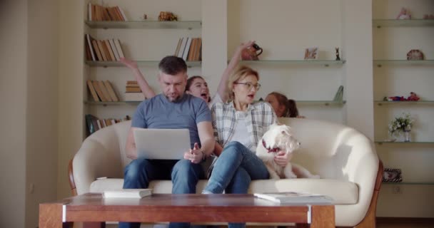 Müdes Ehepaar Frau und Mann sitzen auf Couch fühlt sich genervt, während laute kleine Tochter schreit springen auf Sofa in der Nähe der Eltern. — Stockvideo