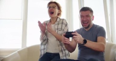 Mutlu Çift Koltukta Oturuyor ve Video Oyunları Oynuyor, Aşk Denetmenlerini Kullanmak Çevrimiçi Video Oyunlarında Birlikte Eğleniyor