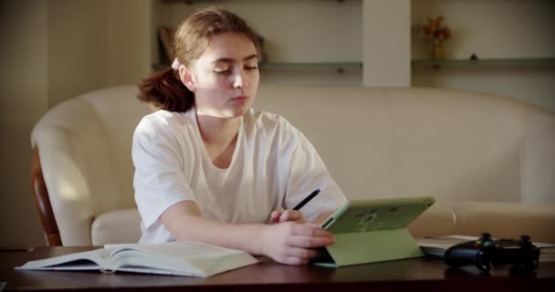 Girl using digital tablet technology device in an online lesson, talking on video via tablet — Stock video