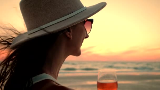 Femme tenant classe de vin regardant coucher de soleil sur l'océan bénéficiant d'une vue imprenable — Video