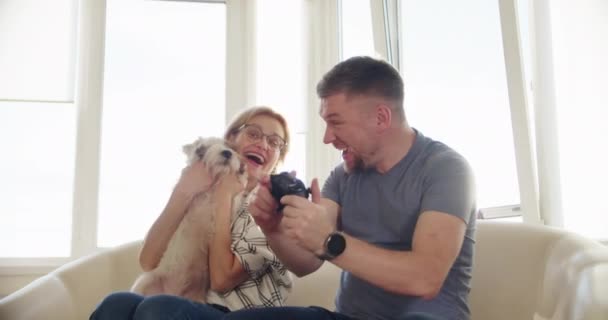 Happy Couple Sitting on the Sofa and Playing Video Games, Using Controllers in Love have Fun Playing in Online Video Games Together. Close up — Stock Video