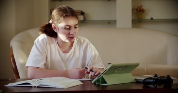 Chica que utiliza el dispositivo de tecnología tableta digital en una lección en línea, hablando en vídeo a través de la tableta. De cerca. — Vídeos de Stock