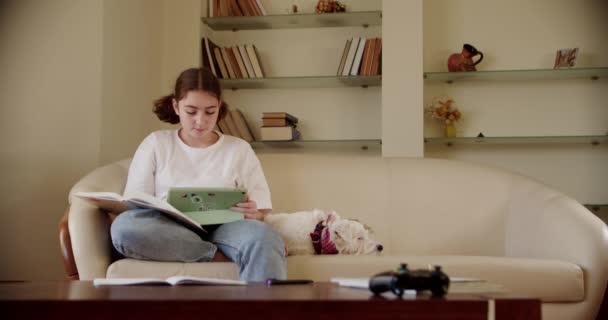 Dziewczyna używająca cyfrowego tabletu w lekcji online, rozmawiająca na video przez tablet. Szeroki materiał — Wideo stockowe