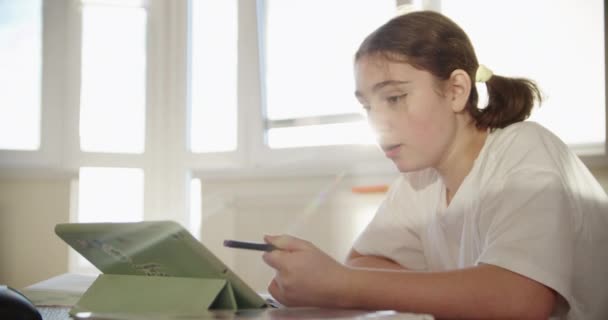 Menina usando dispositivo de tecnologia de tablet digital em uma lição on-line, falando em vídeo via tablet. Imagens de perto — Vídeo de Stock