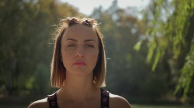 Portre Kadını, güneşli bir günde dışarıda yoga egzersizi yapıyor..